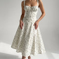 Elodie Floral Midi Dress worn by a model in a softly lit grey studio
