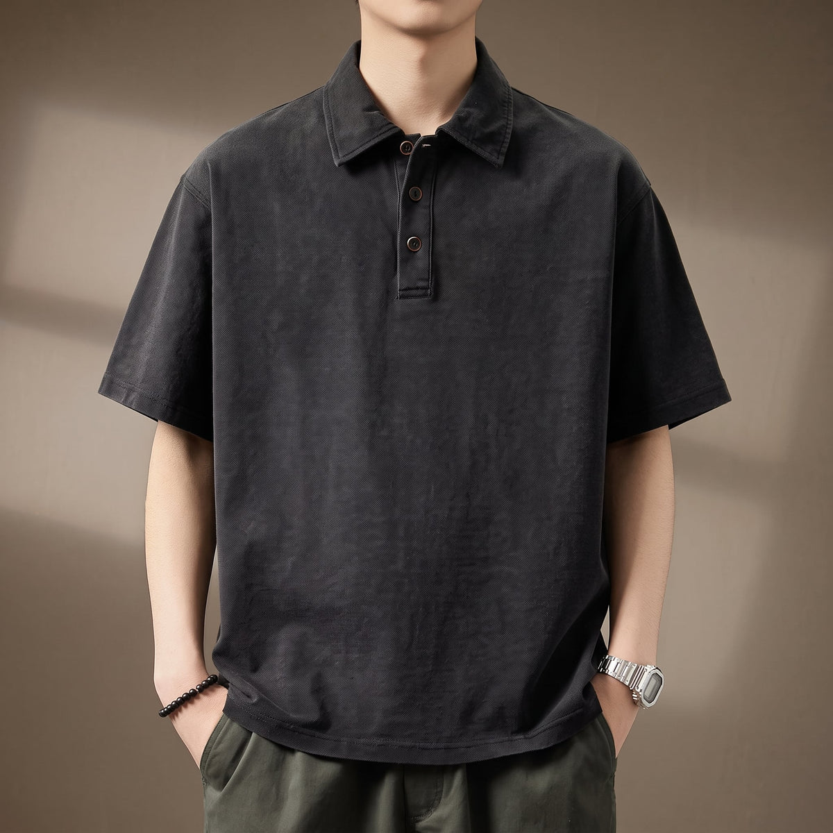 Bryson Men's Denim Polo Shirt in Black against a warm taupe studio background