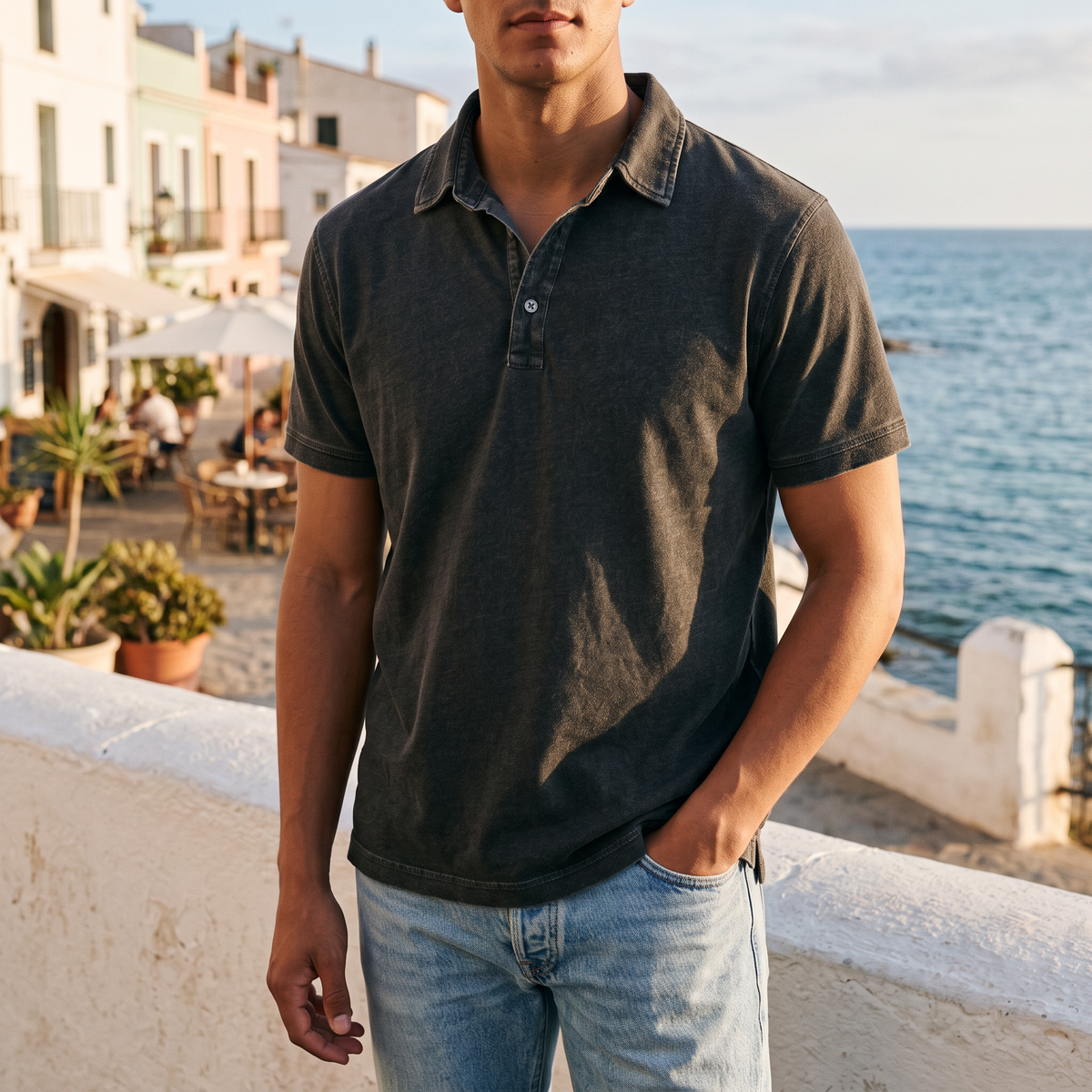 Callum Men's Denim-Wash Cotton Polo Shirt in black on a beachside town terrace