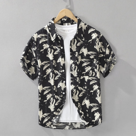 Havlock Men's Button-Up Short Sleeve Shirt hanging over a white top against a grey wall