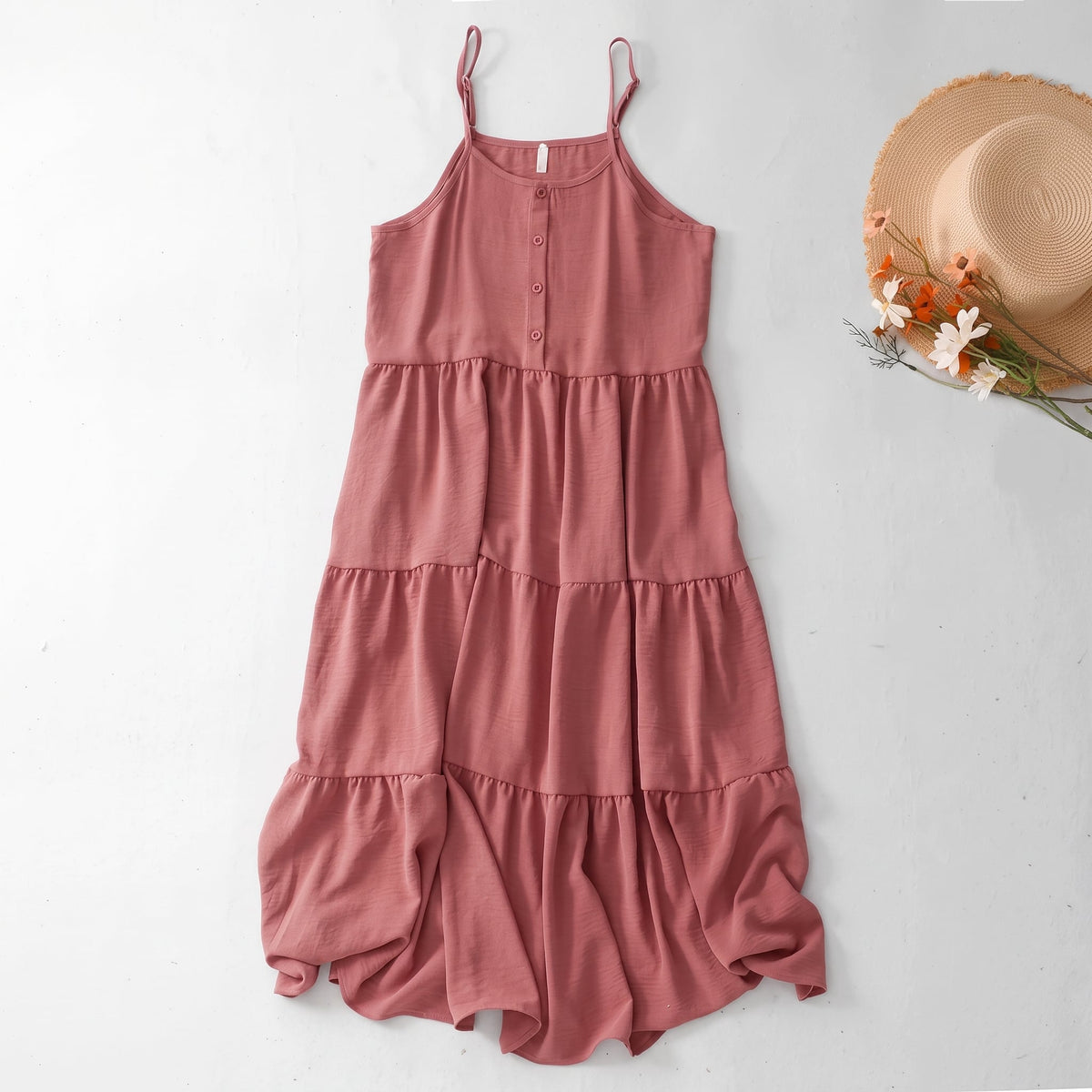 Primrose Cotton Spaghetti Strap Sundress arranged flat beside a straw hat and flowers