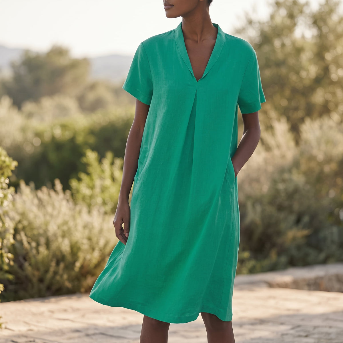 Riviera Women's Cotton V-Neck Midi Dress in Green in a sunlit outdoor setting