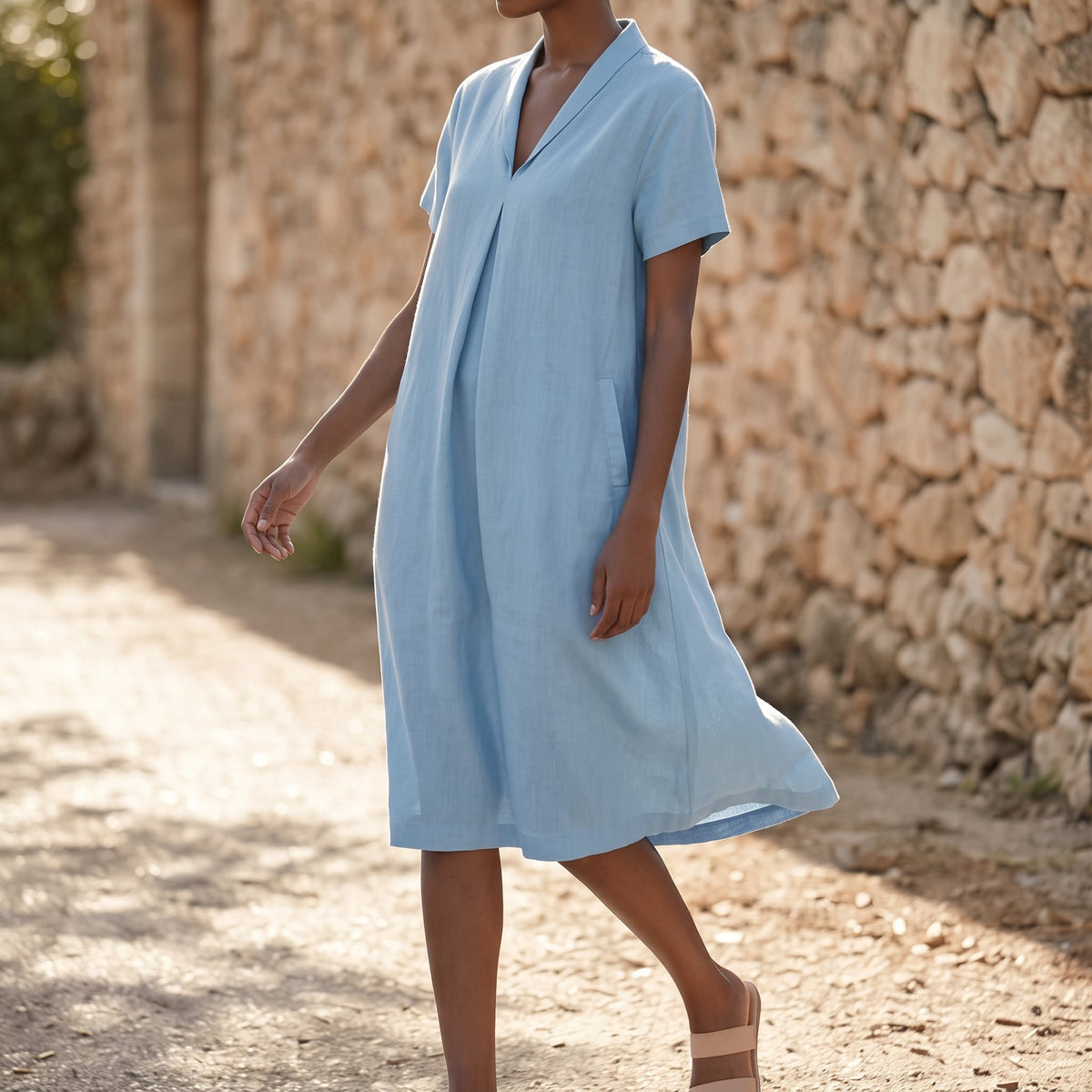 Riviera Women's Cotton V-Neck Midi Dress worn on a sunlit lane beside a stone wall