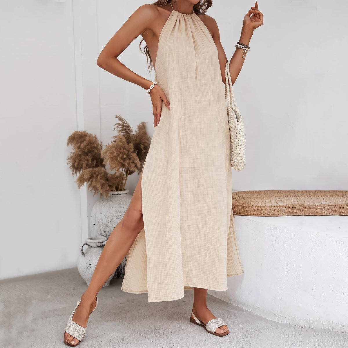 Senna Linen Halter Maxi Dress worn in a neutral interior beside a bench
